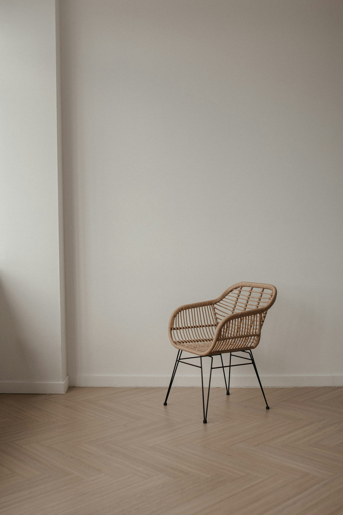 Wicker chair with metal legs on a wooden floor