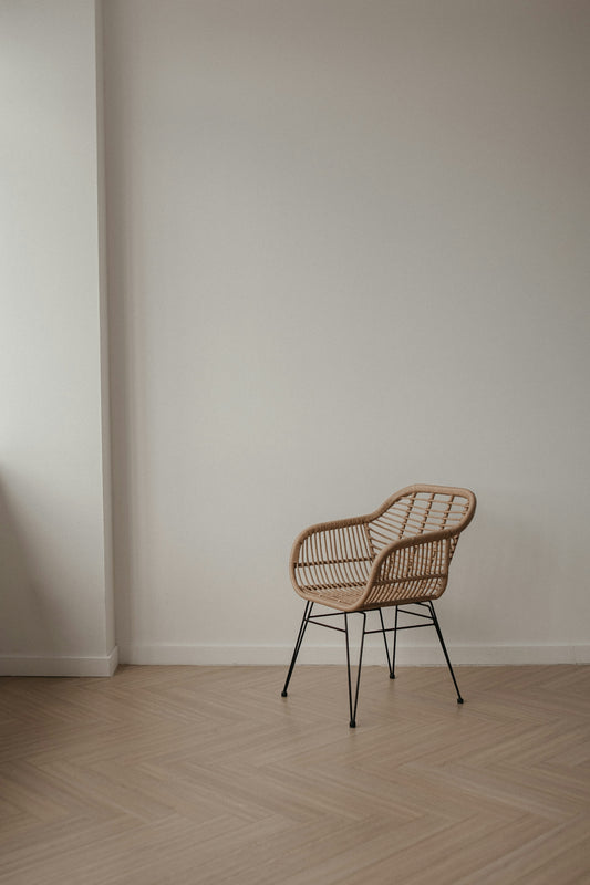 Wicker chair with metal legs on a wooden floor